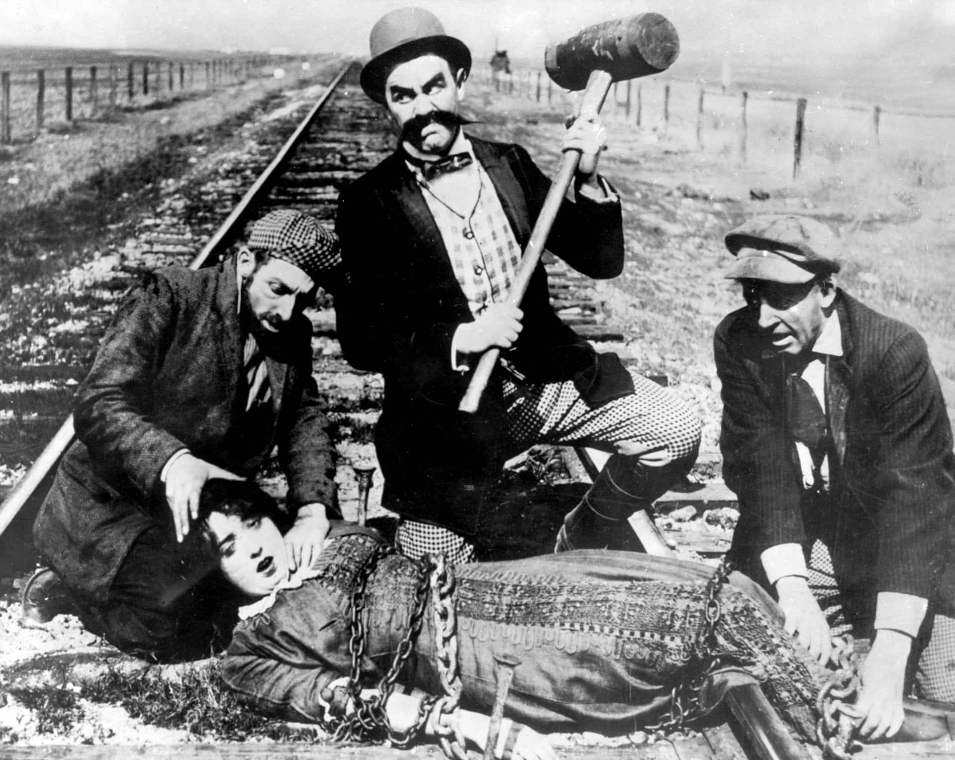 صحنه‌ای از فیلم رقابت برای زندگی (1913): نورم‌اند اولین دختری که بر پرده‌ی سینما به ریل قطار بسته شد